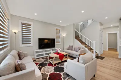 a living room with two couches and a tv at Brand New Modern Home - 5 Beds - Office - Garage - Luxury Living - Sleeps 9 in Calgary