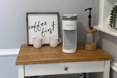 a coffee maker on a table with two cups at Newly Renovated, Bright & Cozy 3 bdrm Home - 6min from Rogers Arena in Edmonton