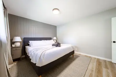 a bedroom with a bed with a cat sitting on it at Newly Renovated, Bright & Cozy 3 bdrm Home - 6min from Rogers Arena in Edmonton