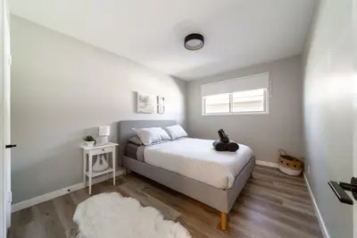 a bedroom with a bed and a window at Newly Renovated, Bright & Cozy 3 bdrm Home - 6min from Rogers Arena in Edmonton