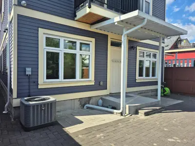 a blue house with a porch and a trash can at Entire ground floor 2 Baths 3 Beds Full Privacy in Vancouver