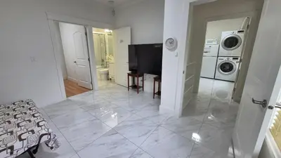 a living room with a television and a washing machine at Entire ground floor 2 Baths 3 Beds Full Privacy in Vancouver