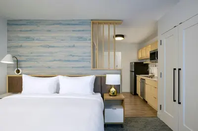 a bedroom with a bed and a kitchen at TownePlace Suites by Marriott Victoria Airport Sidney in Sidney