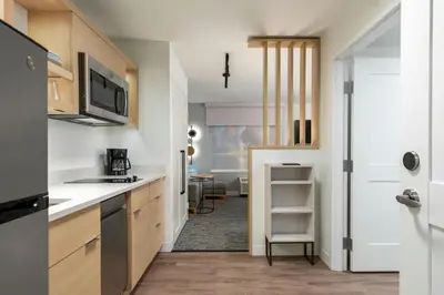a kitchen with white countertops and a door to a room at TownePlace Suites by Marriott Victoria Airport Sidney in Sidney