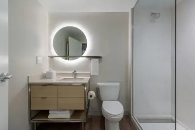 a bathroom with a toilet and a sink and a shower at TownePlace Suites by Marriott Victoria Airport Sidney in Sidney