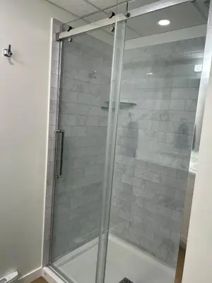 a shower with a glass door in a bathroom at The Basement Suite on Paradise Hill in Prince George