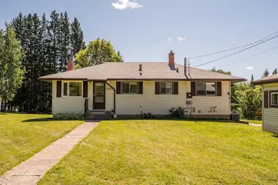 a house with a grass yard in front of it at The Basement Suite on Paradise Hill in Prince George