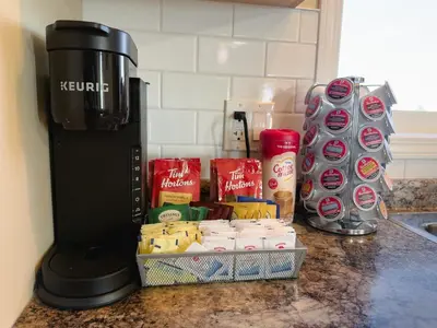 a coffee maker on a counter next to a container of food at Spacious 4BR with King Suite - Garage - Netflix in Lloydminster