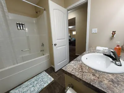 a bathroom with a sink and a shower and a tub at Spacious 4BR with King Suite - Garage - Netflix in Lloydminster
