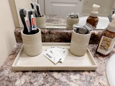 a tray with toothbrushes in cups on a bathroom counter at Spacious 4BR with King Suite - Garage - Netflix in Lloydminster