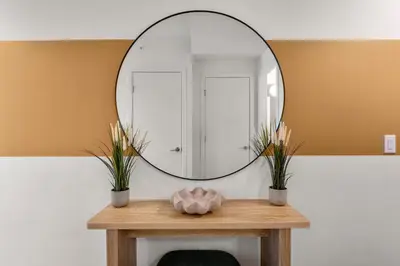 a round mirror on a table in a bathroom at Incredible DT Views| King bed| Rest and Unwind in Calgary