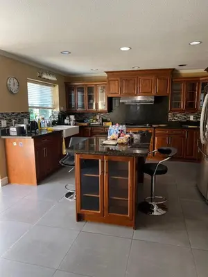 a kitchen with wooden cabinets and a large island at Bright, modern & spacious luxurious Master Bedroom in prime Golden village Richmond, in Richmond