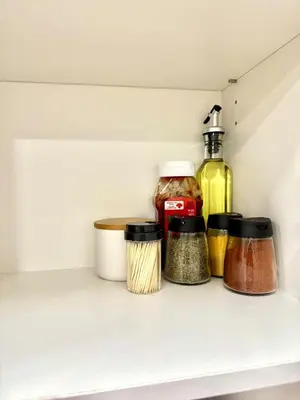 a shelf in a refrigerator with spices and oils at Stylish and Cozy 2-Bedroom Guest Suite in West Edmonton in Edmonton