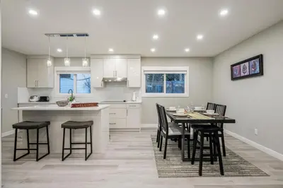 a kitchen and dining room with a table and chairs at Renovated 3BE, 2BA close to UoC, downtown, SAIT in Calgary