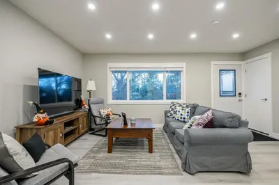 a living room with a couch and a tv at Renovated 3BE, 2BA close to UoC, downtown, SAIT in Calgary