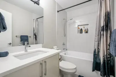 a white bathroom with a sink and a toilet at Renovated 3BE, 2BA close to UoC, downtown, SAIT in Calgary