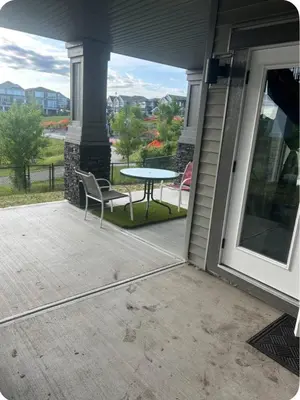 a patio with a table and a chair on a porch at Pond view Place in Airdrie