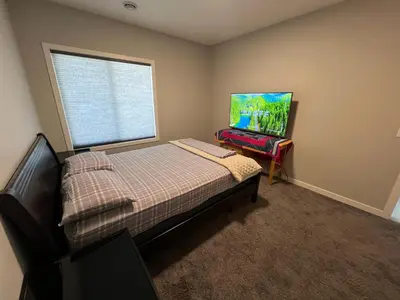 a small bedroom with a bed and a window at Pond view Place in Airdrie