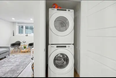 a white washer and dryer in a living room at Luxury brand new 1 Bedroom Townhome in Calgary