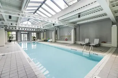 a large swimming pool with a large ceiling at Extra Spacious with a King Bed Sauna Pool & Jacuzzi in Vancouver