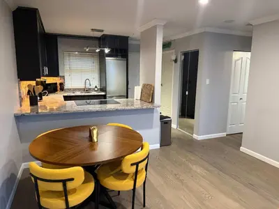 a kitchen with a wooden table and yellow chairs at Extra Spacious with a King Bed Sauna Pool & Jacuzzi in Vancouver