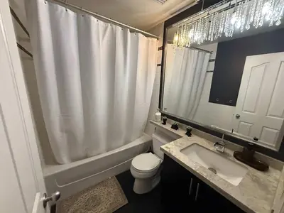 a bathroom with a toilet and a sink and a mirror at Extra Spacious with a King Bed Sauna Pool & Jacuzzi in Vancouver