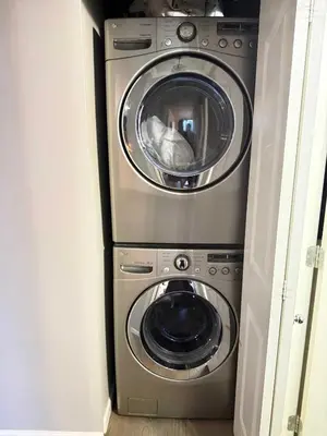 a washing machine and a washer and dryer in a room at Extra Spacious with a King Bed Sauna Pool & Jacuzzi in Vancouver