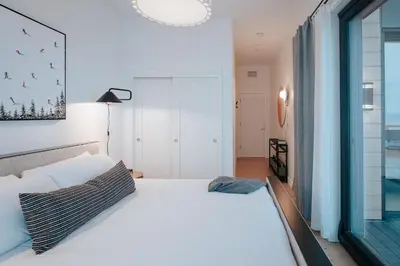 a bedroom with a white bed and a window at Gary's Birthday by Revelstoke Vacations in Revelstoke