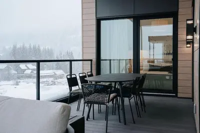 a balcony with a table and chairs and a bed at Gary's Birthday by Revelstoke Vacations in Revelstoke