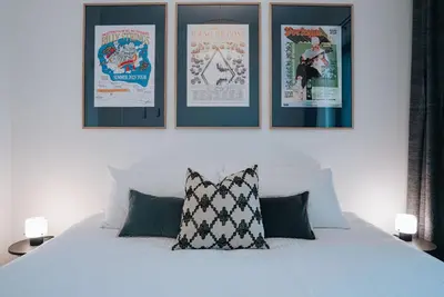 a bedroom with a white bed with four posters on the wall at Gary's Birthday by Revelstoke Vacations in Revelstoke
