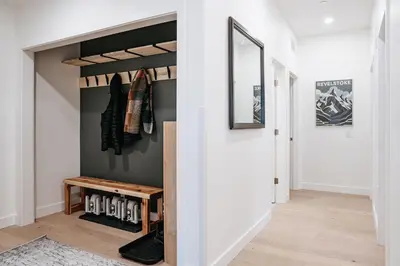 a hallway with a closet with a wooden bench in it at Cloudscape Penthouse by Revelstoke Vacations in Revelstoke