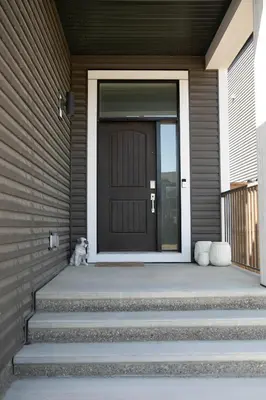 a door to a house with a dog sitting on the porch at Scenic Cochrane Family Home in Cochrane