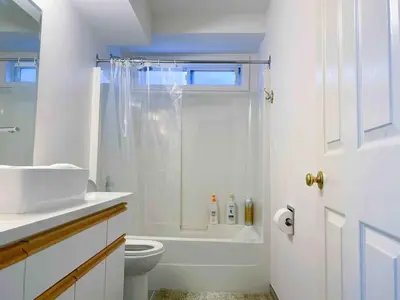 a white bathroom with a shower and a toilet at 2BR sweet suite in Nanaimo