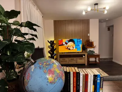 a living room with a tv and a globe and books at 2BR sweet suite in Nanaimo