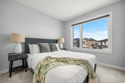 a bedroom with a bed and a large window at Modern 4BR Retreat 3 Baths Near to Banff&Airport in Calgary
