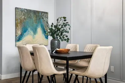 a dining room with a black table and chairs at Modern 4BR Retreat 3 Baths Near to Banff&Airport in Calgary