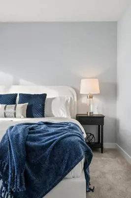 a bedroom with a bed with a blue blanket on it at Modern 4BR Retreat 3 Baths Near to Banff&Airport in Calgary