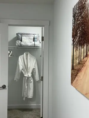 a white shirt on a shelf in a closet at Slice of Heaven! 3 Bdrm Duplex 10 minutes drive to Spruce Meadows, with easy access to Stampede and Banff, CENTRAL AC available Mid Spring 2026! in Calgary