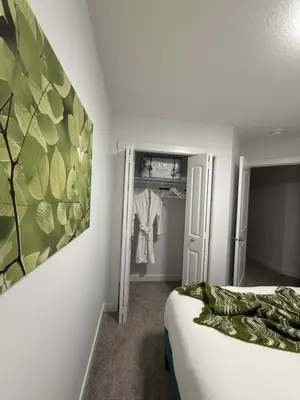 a bedroom with a bed and a painting on the wall at Slice of Heaven! 3 Bdrm Duplex 10 minutes drive to Spruce Meadows, with easy access to Stampede and Banff, CENTRAL AC available Mid Spring 2026! in Calgary