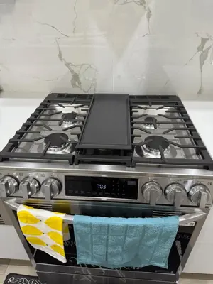 a stove top oven sitting in a kitchen at Slice of Heaven! 3 Bdrm Duplex 10 minutes drive to Spruce Meadows, with easy access to Stampede and Banff, CENTRAL AC available Mid Spring 2026! in Calgary