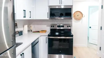 a kitchen with a stove and a microwave at Ebenz Apartment in Calgary