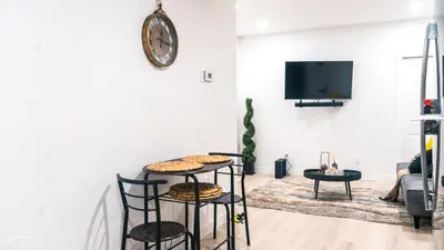 a living room with two black chairs and a tv at Ebenz Apartment in Calgary