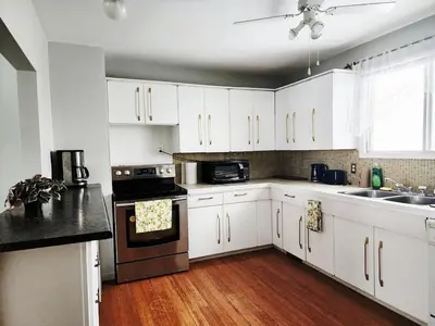 a kitchen with white cabinets and a stove top oven at House in Edmonton