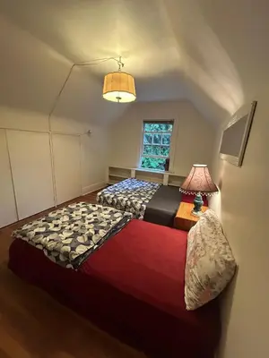 a bedroom with two beds and a lamp and a window at Vancouver Airport Rooms - Free Parking, Fast WiFi, Near Transit in Vancouver