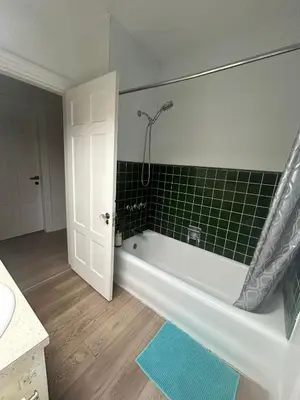 a bathroom with a bath tub with green tile at Vancouver Airport Rooms - Free Parking, Fast WiFi, Near Transit in Vancouver