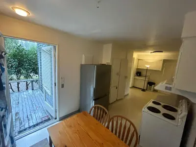a kitchen with a refrigerator and a table with chairs at Vancouver Airport Rooms - Free Parking, Fast WiFi, Near Transit in Vancouver