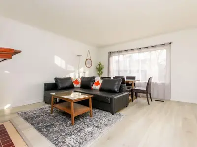 a living room with a black couch and a table at Cozy 2BR 1BA Retreat in Vibrant Vancouver in Vancouver
