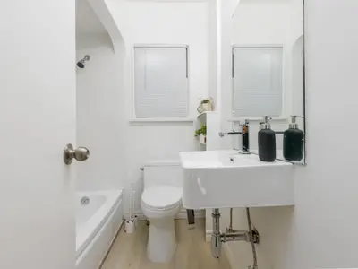 a bathroom with a sink and a toilet and a tub at Cozy 2BR 1BA Retreat in Vibrant Vancouver in Vancouver