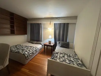 a bedroom with two beds and a table with a lamp at Vancouver Budget Rooms Near Beach & Transit - Fast WiFi & Free Parking in Vancouver