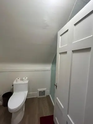 a bathroom with a white toilet and a door at Budget Vancouver Rooms Near YVR - Free Parking, Fast WiFi in Vancouver
